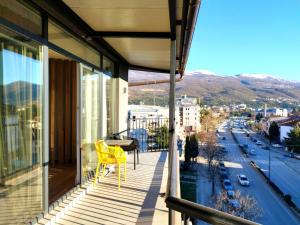 einen gelben Stuhl auf einem Balkon mit Stadtblick in der Unterkunft Urban Vista Apartments in Ohrid