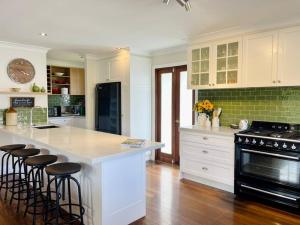 a kitchen with a large island with bar stools at Mountview Alpaca Farmhouse in Canungra