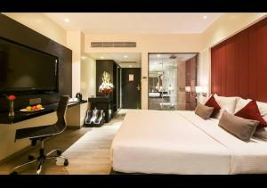 Hotel Suncity Residency في مومباي: غرفة نوم بسرير ابيض كبير وكرسي
