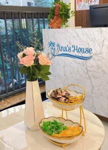 una mesa con dos tazones de comida y un jarrón con flores en Ana's House, en Quy Nhon