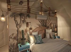 a bedroom with a bed with a tree and lights at Sun&Sand Camps Bay in Cape Town