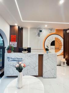 a lobby with a counter with a vase of flowers at Ana's House in Quy Nhon