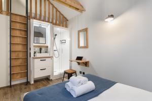 Dormitorio pequeño con cama y ducha en Le Petit Chalet - Maison 2 chambres avec terrasse en Rennes