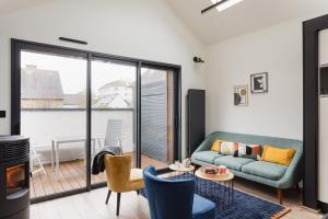 sala de estar con sofá y balcón en Le Petit Chalet - Maison 2 chambres avec terrasse en Rennes