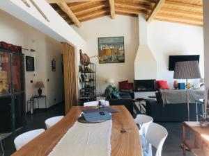 a living room with a wooden table and chairs at Villa Coco , un lieu convivial où se ressourcer. in Kalafatiónes