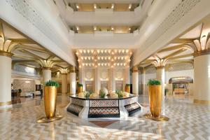 a lobby of a hotel with gold pillars and a table at InterContinental Jeddah, an IHG Hotel in Jeddah
