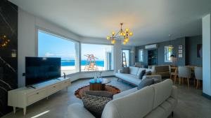 sala de estar con TV y ventana grande en Villa Valentino1, en Karabağ