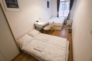 a small room with two beds and a table at Pest-port apartment 4 rooms for 16 person in Budapest