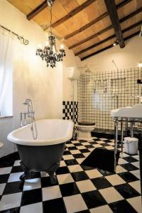 a bathroom with a tub and a checkered floor at Casale Armonia in Massa Martana