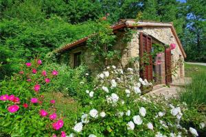 einen Garten mit rosa und weißen Blumen vor einem Gebäude in der Unterkunft Casale Armonia in Massa Martana