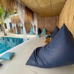 a resort with a swimming pool with blue pillows at Acqualanta House in Ko Lanta