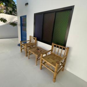 two wooden chairs sitting on the porch of a house at Acqualanta House in Ko Lanta