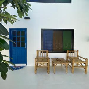 duas cadeiras e uma mesa e uma porta azul em Acqualanta House em Ko Lanta