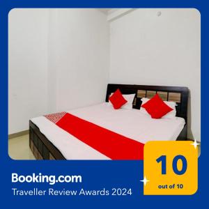 a bedroom with a bed with red pillows at OYO Flagship Shine Hotel in Chinhat