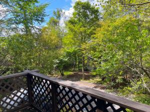 忍野村的住宿－【富士ビューロッジ】自然豊かなBBQ体験！一棟貸しログハウス，一座木桥,通往种有树木的花园