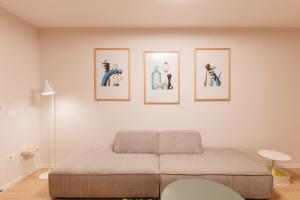 ein Schlafzimmer mit vier Bildern an der Wand in der Unterkunft GreyGreen by Holistay in Tirana