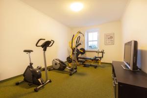 a gym with several exercise bikes and a television at Appartements Feroli in Dienten am Hochkönig