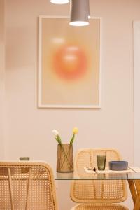 Ein Tisch mit zwei Stühlen und ein Bild an der Wand in der Unterkunft GreyGreen by Holistay in Tirana