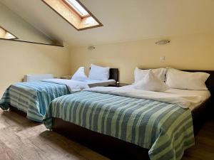 LipovaにあるCasa Maria Magdalenaのベッド2台が隣同士に設置された部屋です。