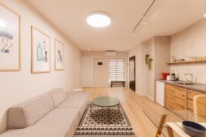 ein Wohnzimmer mit Sofa und Tisch in der Unterkunft GreyGreen by Holistay in Tirana