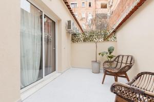 einen leeren Balkon mit einem Stuhl und einer Pflanze in der Unterkunft GreyGreen by Holistay in Tirana