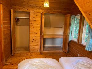 忍野村的住宿－【富士ビューロッジ】自然豊かなBBQ体験！一棟貸しログハウス，一间卧室配有一张床和一个步入式衣柜