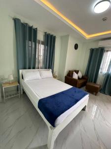 1 dormitorio con 1 cama grande con manta azul en Faith Street Airbnb en Plaridel
