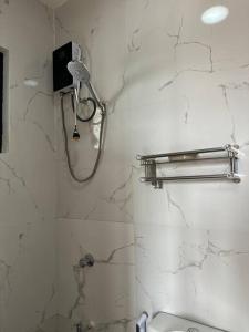a bathroom with a shower with a phone on the wall at Faith Street Airbnb in Plaridel