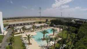 an overhead view of a resort with a pool and palm trees at Eureka Palace Hotel Spa Resort in Cassibile