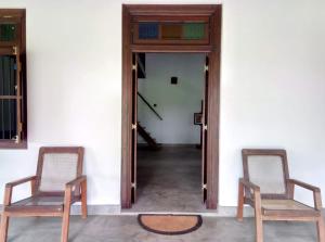 two chairs sitting in a room with a doorway at Antique Villa in Ranna