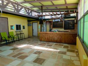 a large room with a kitchen with green chairs at Majuro see breeze suites in Majuro