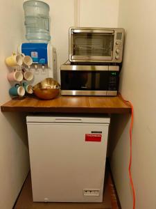 a microwave oven sitting on top of a small refrigerator at Majuro see breeze suites in Majuro