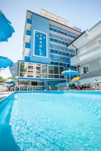 um hotel com piscina em frente a um edifício em Hotel Bagli em Rimini