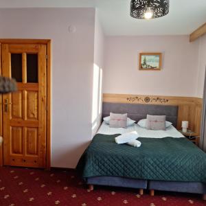1 dormitorio con 1 cama con edredón verde en Willa u Kośle Zakopane en Zakopane