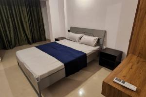 1 dormitorio con cama y mando a distancia en 2bhk cozy apt near baina beach, en Vasco Da Gama