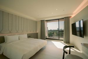 Posteľ alebo postele v izbe v ubytovaní XIUXI Anping Hotel