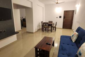 a living room with a blue couch and a table at 2bhk cozy apt near baina beach in Vasco Da Gama
