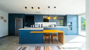 cocina con armarios azules y encimera amarilla en Villa Valentino1, en Karabağ