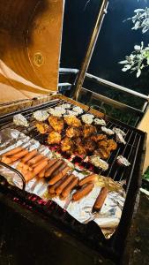 a grill with hot dogs and other foods on it at White Villa Kitulgala in Kitulgala