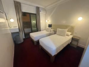 a hotel room with two beds and a mirror at Crystal boulevard Single/Double in Tangier