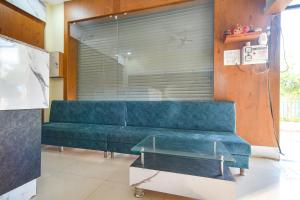 a blue couch in a room with a large window at FabHotel Grand Giriraj in Indore