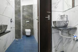 a bathroom with two sinks and a toilet at FabHotel Grand Giriraj in Indore