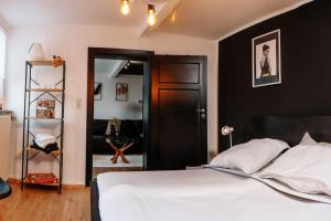 a bedroom with a white bed and a black wall at Modern & black - City - Netflix - Wifi - 4 Person in Bochum +9 photos