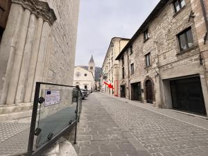 an empty street in an old building with a red flag at Affittacamere Casa Matilde in Gualdo Tadino