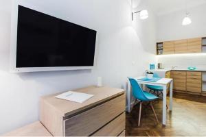 a living room with a desk and a television on a wall at Perfect place to stay in Kraków City Center 30m2 W2 in Krakow