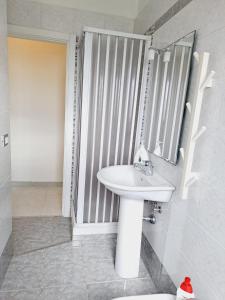 La salle de bains est pourvue d'un lavabo et d'un miroir. dans l'établissement Villino due palme, à Palumbo