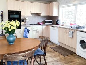 a kitchen with a table and a vase of flowers at Sandy Bay in Portmahomack