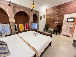 um quarto com 2 camas e uma parede de pedra em Karma homestay em Jodhpur