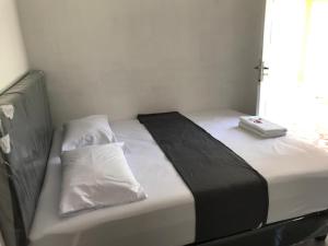 Una cama con una manta blanca y negra y una ventana en QQ HOMESTAY, en Takengon