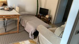 Habitación con cama, escritorio y TV. en Casa di kikka, en Bassano del Grappa